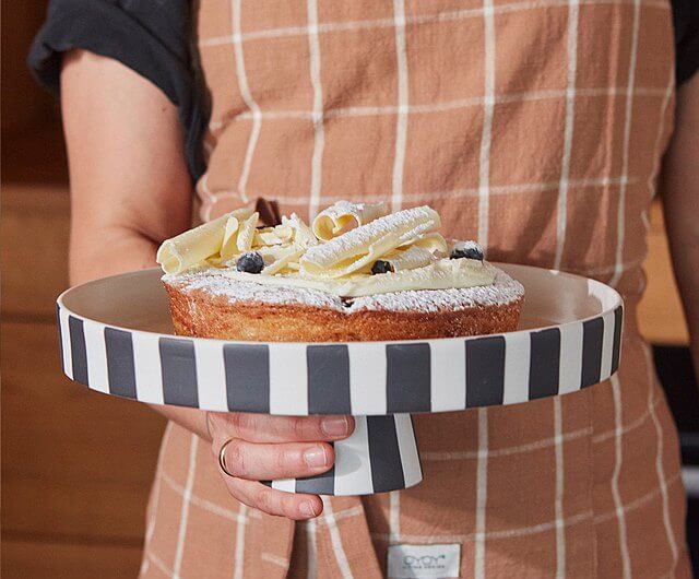 Handmade Ceramic stand with a cake in a mann hands